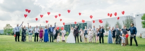Hochzeitsgesellschaft lässt rote Herzluftballons in die Luft steigen