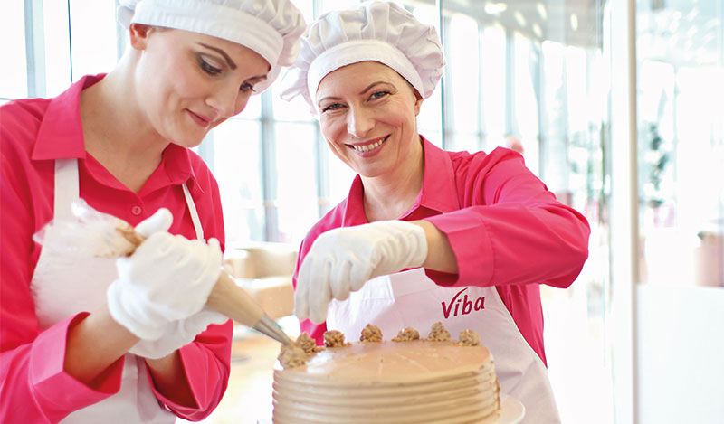 Viba Confiseurinnen dekorieren eine Buttercreme-Torte